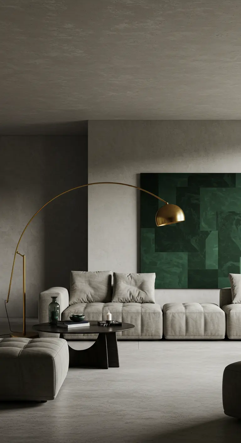 Grijze, minimalistische woonkamer met betonlook, grote beige bank, groen kunstwerk en gouden lamp.