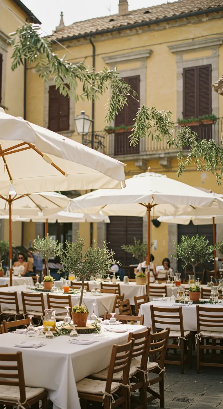 Italiaans plein met tafels, parasols en olijfbomen in pot.