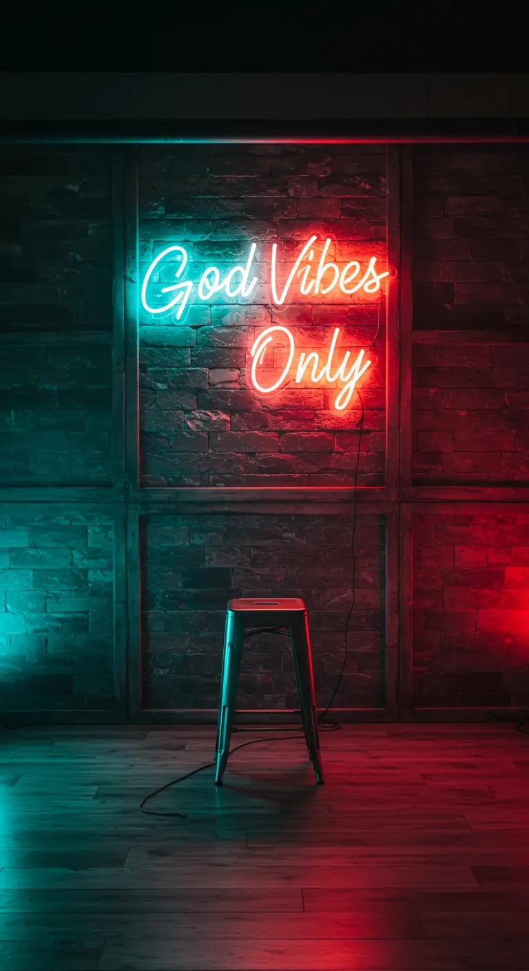 Neonbord 'Good Vibes Only' in rood en turquoise tegen een bakstenen muur.