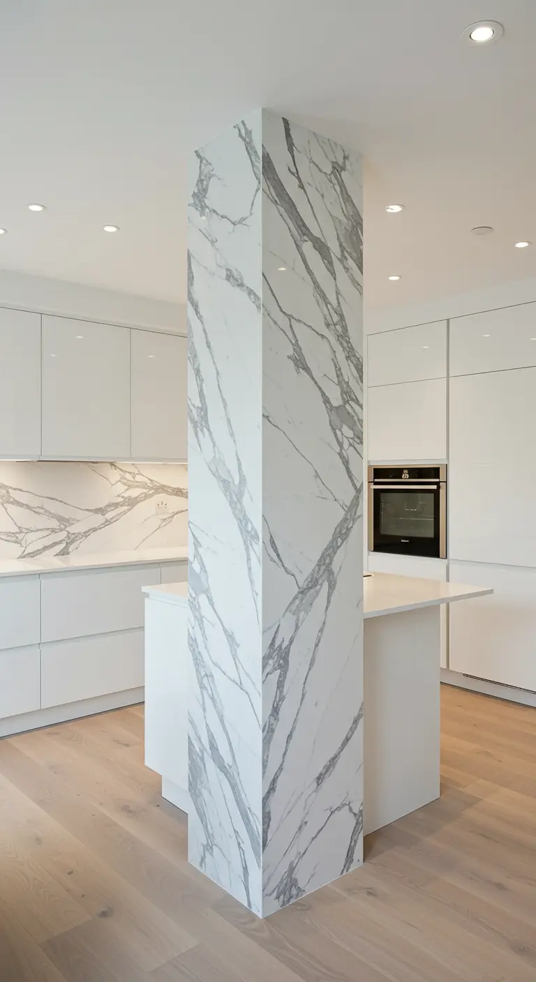 Witte, moderne keuken waarin een structurele pilaar is bekleed met wit marmer.