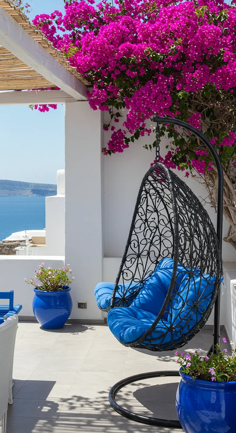 Zwarte eivormige hangstoel met kobaltblauwe kussens, blauwe potten en roze bougainvillea.