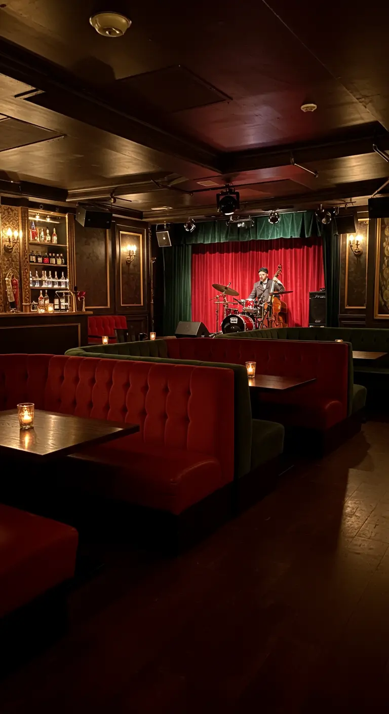 Donkere bar met rode fluwelen banken en een podium.