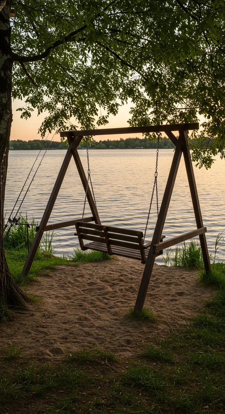 Houten schommelbank aan de rand van een meer, met uitzicht op de zonsondergang.
