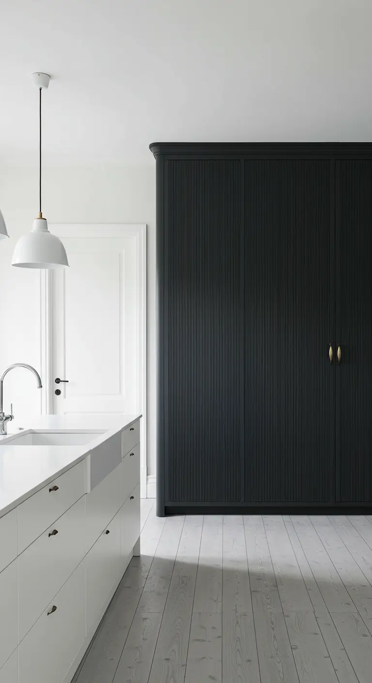 Witte keuken met een contrasterende hoge, matzwarte kastenwand met een geribbeld patroon.