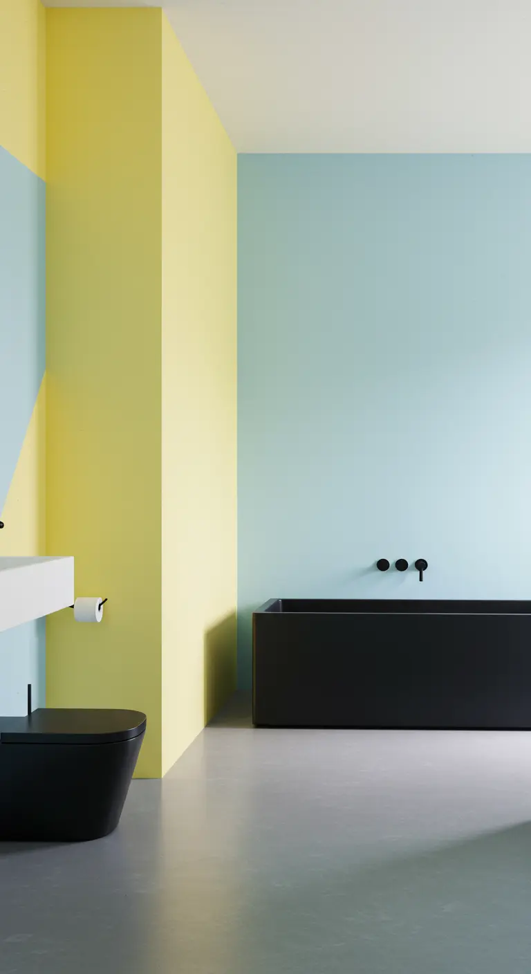 Minimalistische badkamer met kleurvlakken in zachtgeel en lichtblauw en een zwart bad.