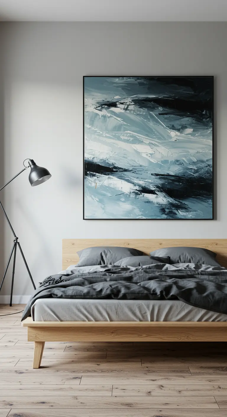 Slaapkamer met een groot abstract schilderij in blauw- en grijstinten boven het bed.