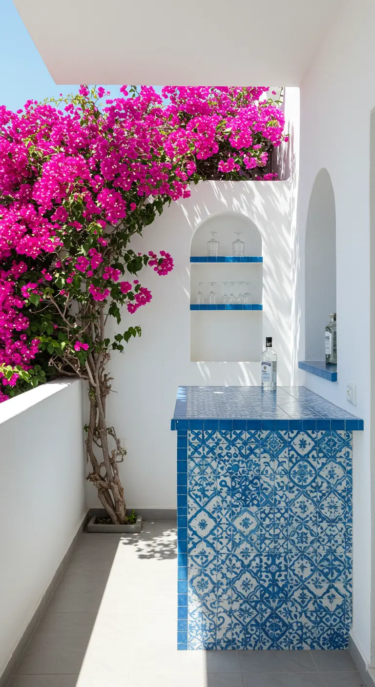 Witte balkonbar met blauwe mozaïektegels en een felroze bougainvillea ernaast.