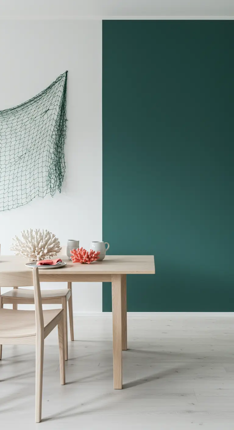 Minimalistische eetkamer met een zeegroene accentmuur, houten tafel en koraalstukken als decoratie.