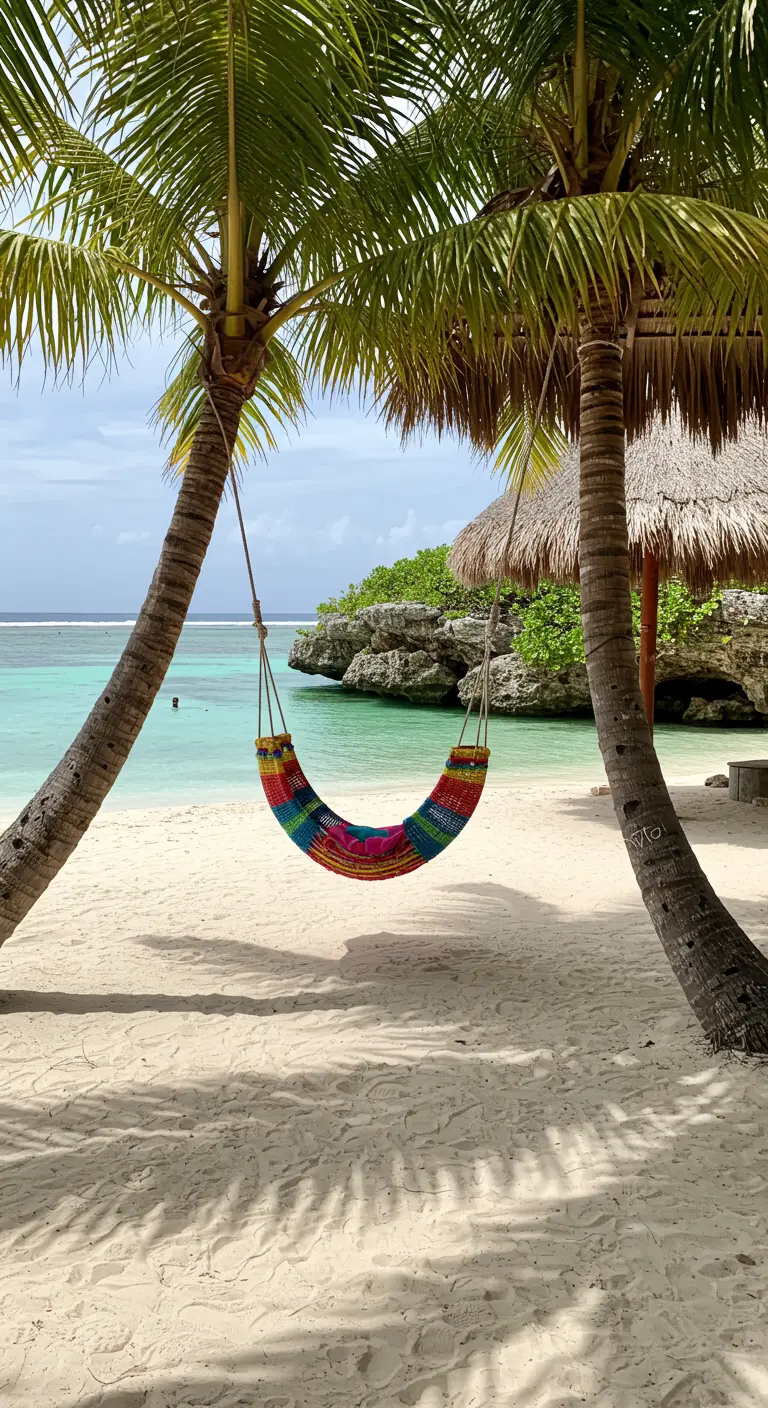 Kleurrijke hangmat-schommel tussen twee palmbomen op een wit zandstrand met turquoise zee.
