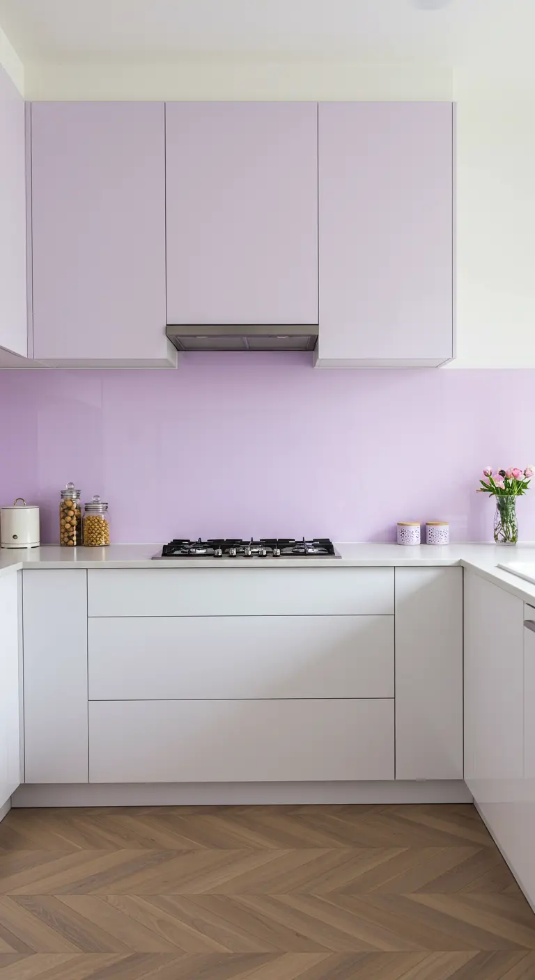 Moderne witte keuken met strakke, lila bovenkasten en een bijpassende glazen achterwand.